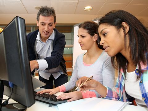Lehrer erklärt 2 Auszubildenden etwas am PC