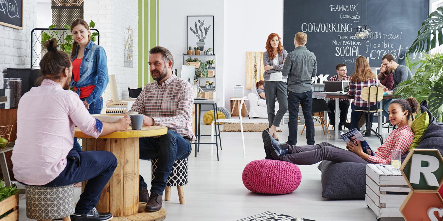 Junge Unternehmerinnen und Unternehmer in Gesprächen in einem Coworking-Space