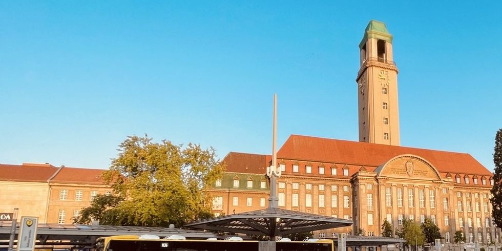 Ein gelber BVG-Bus hält direkt vor dem Rathaus Spandau