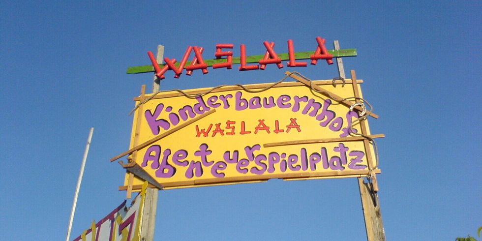 Eingangsschild mit der Aufschrift Kinderbauernhof und Abenteuerspielplatz Waslala