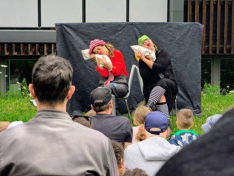Zwei Schauspielerinnen mit Clownsnasen schlafen auf der Bühne
