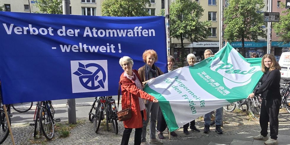 Bezirksbürgermeisterin Clara Herrmann zeigt gemeinsam mit der Initiative der Berliner Mahnwache für das weltweite Verbot der Atomwaffen sowie der Berliner Regionalgruppe des Vereins IPPNW die Flagge der „Mayors for Peace“ (Bürgermeister*innen für den Frieden)