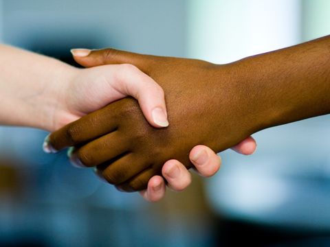 Schwarze und weiße Hand fassen sich an