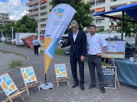 Zwei Männer stehen an einem Stand der Mobilen Stadtteilarbeit Mariendorf-Süd.