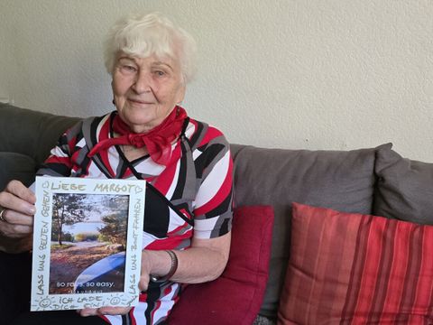 Margot Kutzner zeigt eine Einladung ihrer Lieben zum 85. Geburtstag - mit dem Zelt geht es gemeinsam an den See