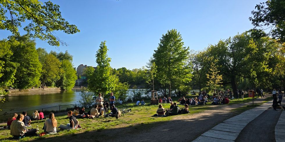 Menschen sitzen am Ufer des Landwehrkanals