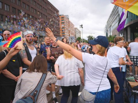 CSD 2025 2025 Parade Laufgruppe mit junger Frau, die Seifenblasen über die Gäste spritzt