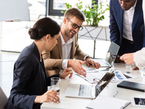 Teilansicht multiethnischer Geschäftsleute am Tisch während der Konferenz im Amt