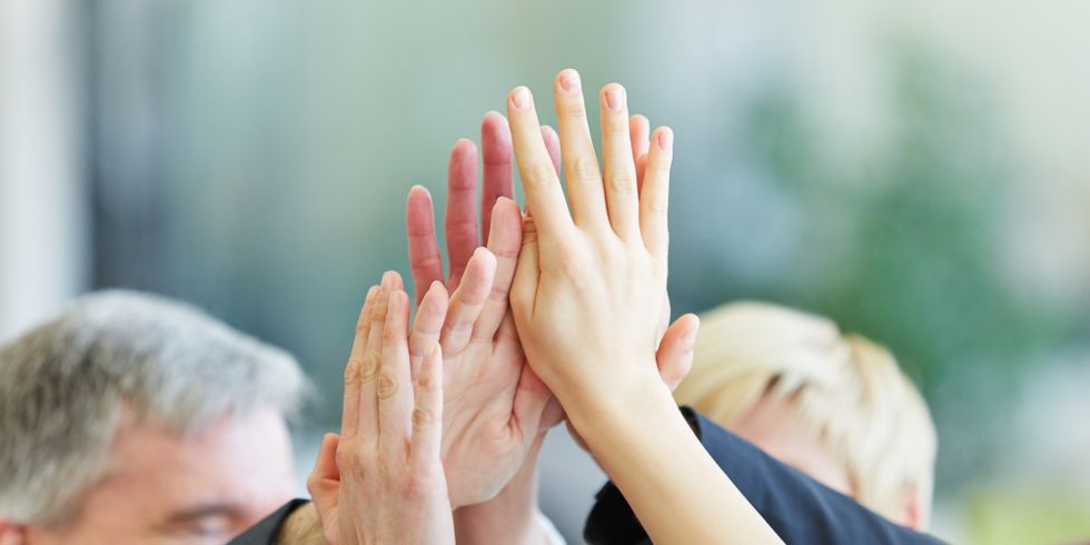 Hände geben sich High Five im Büro
