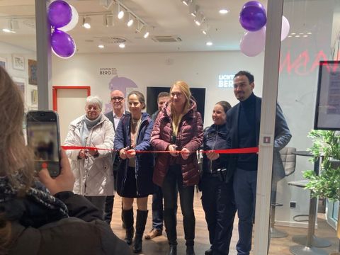 Sieben Personen schneiden ein rotes Band durch.