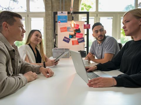Junge Steuerbeamten sitzen in einer gemeinsamen Besprechung