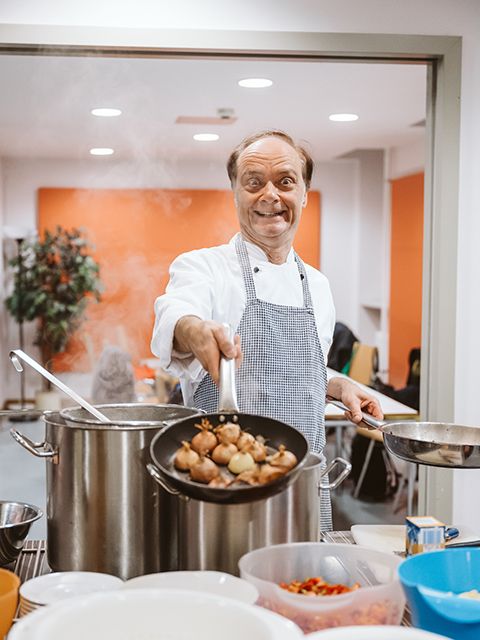 Kochkurs mit Kay Ivers - der Kursleiter hält eine Pfanne mit halben Zwiebeln in die Kamera