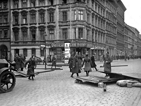 Polizeieinsatz auf einer Berliner Straße: im Vordergrund Material für eine Barrikade, im Hintergrund Demonstranten