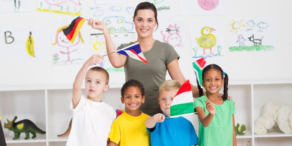 Schulkinder winken mit Fähnchen