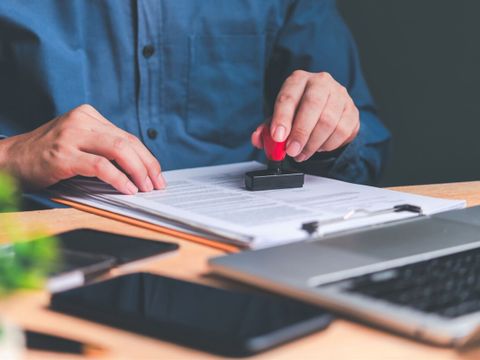 Mann sitzt am Tisch und stempelt