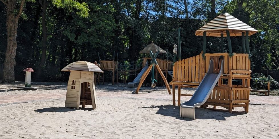 Ein Spielplatz mit unterschiedlichen Elementen, hauptsächlich aus Holz.