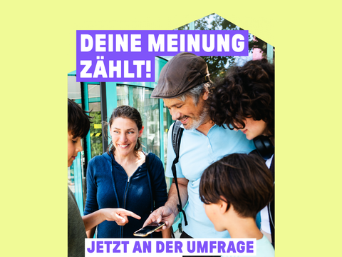 Ein Kind erklärt umstehenden Personen die Umfrage auf dem Handy