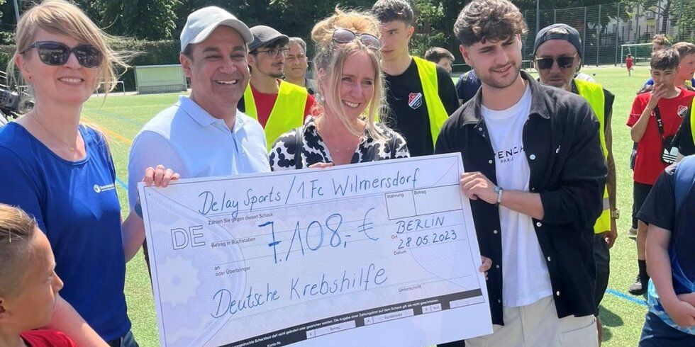 Hamudi Mansour, Vorstandsvorsitzender des 1. FC Wilmersdorf, Elias Nerlich, Gründer des Vereins Delay Sports Berlin und Livestreamer und Webvideoproduzent, überreichte Bezirksbürgermeisterin Kirstin Bauch den Scheck an die Stiftung.