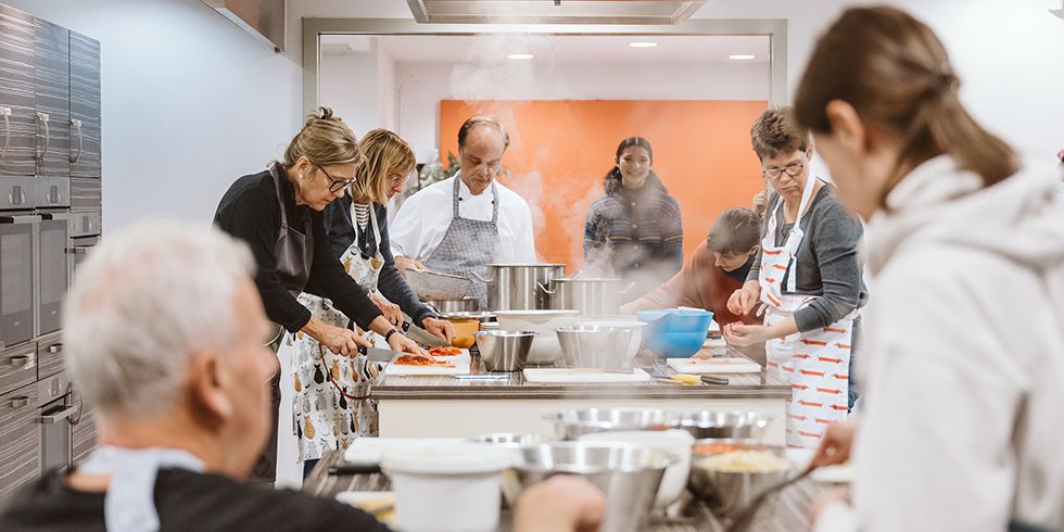 Kochkurs mit Kay Ivers - sieben Teilnehmer:innen beim Zubereiten von Eintöpfen