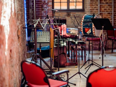 Notenständer und Instrumentarium in einer Saalecke