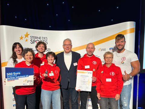 Bezirksstadtrat für Sport, Harald Muschner (CDU), zusammen mit dem 1. Vorsitzenden des SC Tegeler Forst e.V., Marc-Eric Lehmann und einer Abordnung des Vereins bei der Verleihung des Silbernen Sterns bei „Sterne des Sports 2025“ (Bild: BA Reinickendorf)