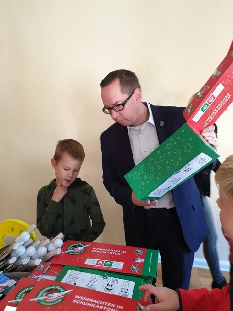 Schüler Benjamin berät Bezirksbürgermeister Igel bei der Aktion Weihnachten im Schuhkarton (Bild: T-B. Ottmar)