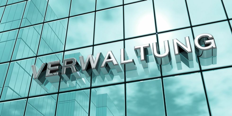 Verspiegelte gekachelte Hausfassade mit dem Wort Verwaltung