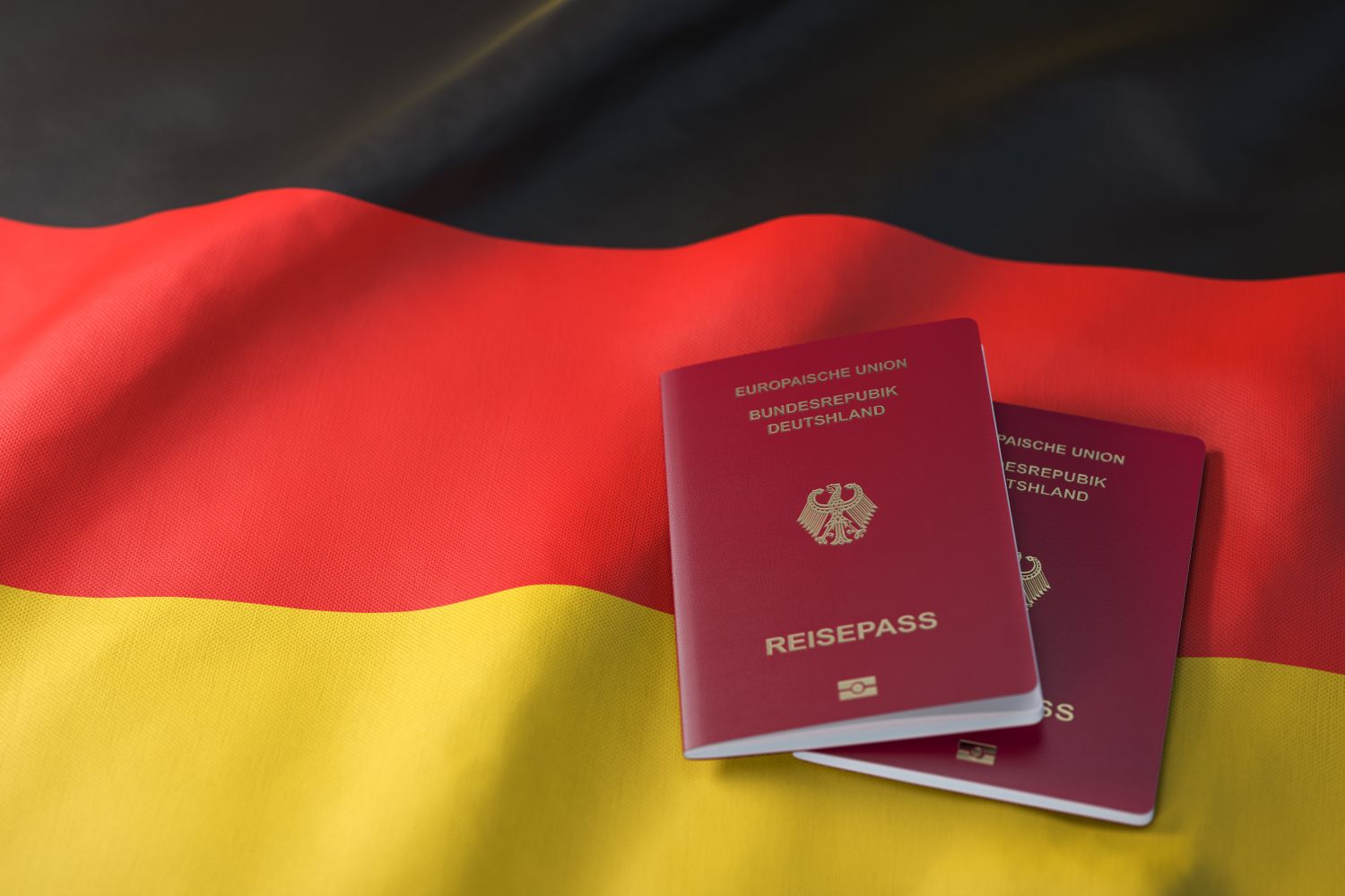 Zwei deutsche Reisepässe liegen auf der deutschen Flagge mit den Farben schwarz-rot-gold
