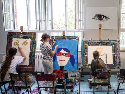 Freies Malen: Drei Kinder malen an der Staffelei.