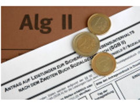 Euro-Münzen liegen auf einem Alg-II-Antrag