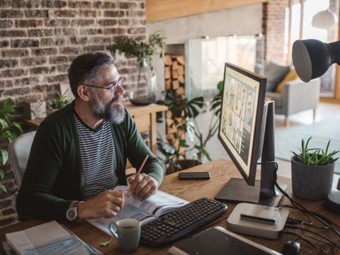 Teilnehmer sitzt am Arbeitsplatz und nimmt an einer Onlinekonferenz teil