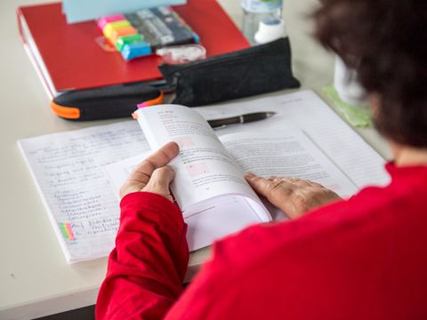 Person liest in einem aufgeschlagenen Buch