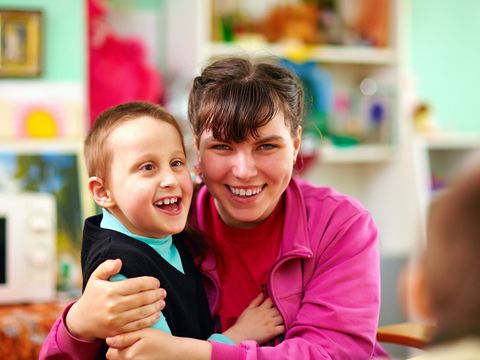 Lächelnder Junge und lächelndes Mädchen mit geistiger Behinderung in einer Rehabilitationseinrichtung