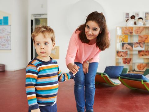 Erzieherin spricht mit Jungen in Kita