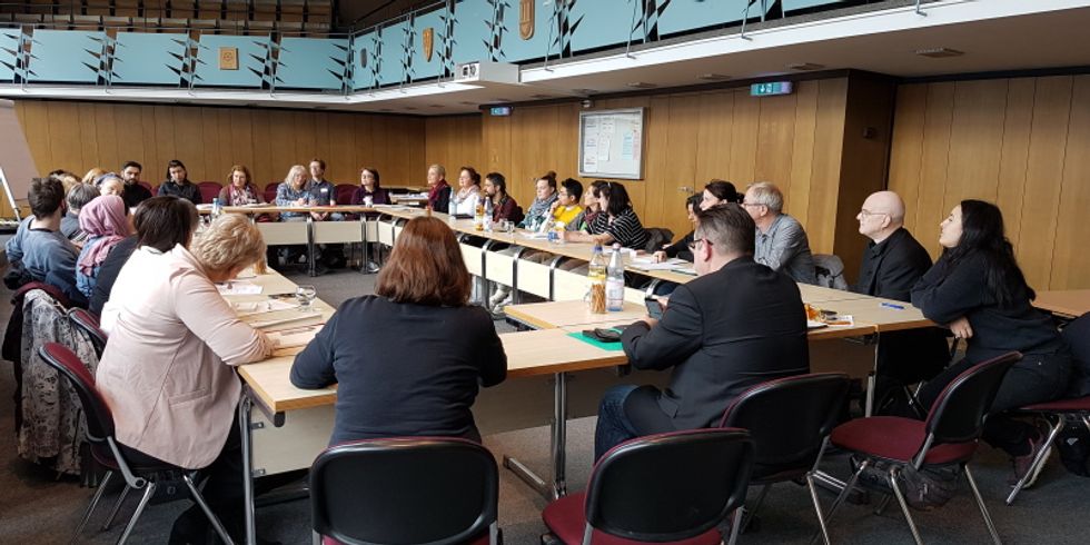 30 Personen diskutieren im Saal der Bezirksverordnetenversammlung