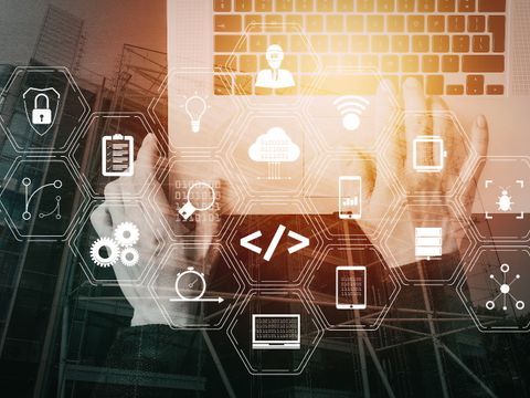 Hände auf einer Laptoptastatur mit darüberliegenden Computersymbolen