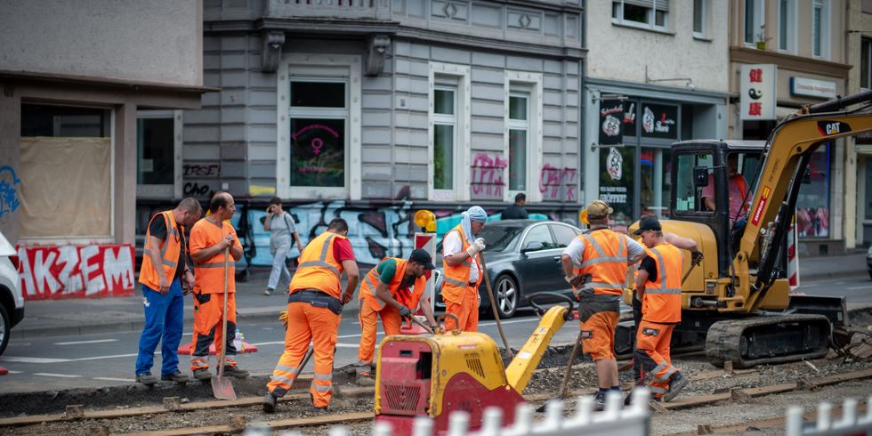 Beschäftigte im Straßenbau bei Arbeiten an einem Straßenbahngleis