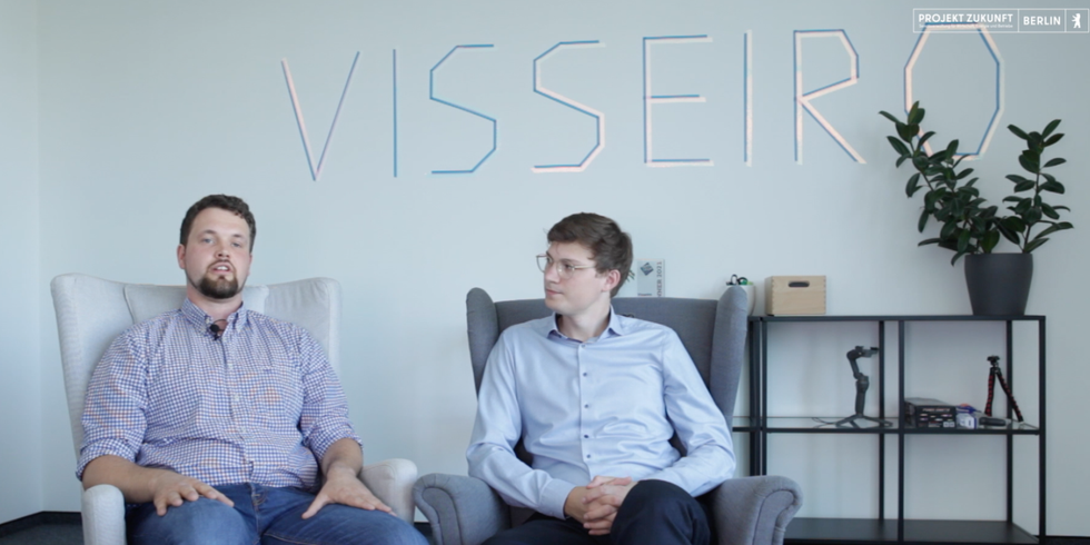 Die Gründer Primin und Janek in der Totale vor Wand mit Visseiro Logo