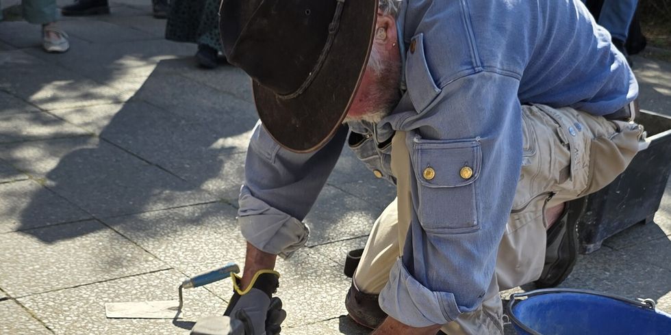 Eine Person verlegt Stolpersteine