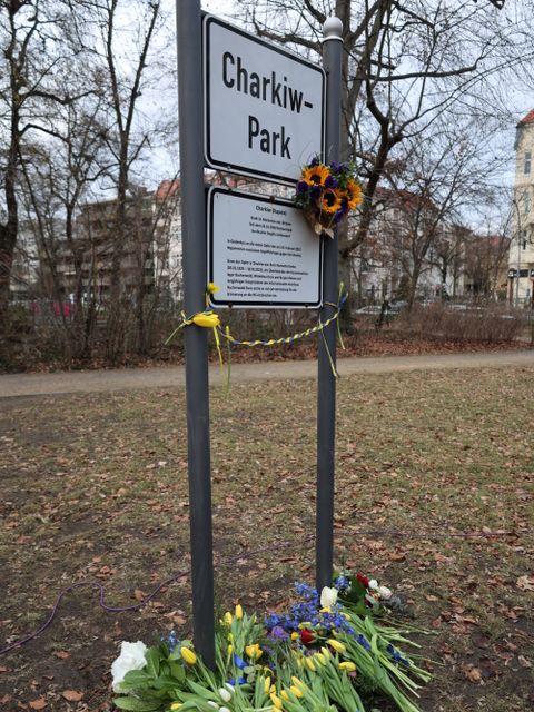 24. Februar 2026: Besucherinnen und Besucher der Gedenkveranstaltung legen Blumen in den ukrainischen Nationalfarben nieder