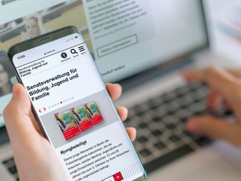 Laptop und Handy mit Seiten der Senatsverwaltung