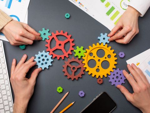 Symbol für Teamarbeit: Bunte Zahnräder, die gemeinsam ineinandergreifen