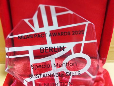 Ein Award aus Plexiglas mit der Aufschrift "Milan Pact Awards 2025, Berlin, Special Mention, Sustainable Diets & Nutrition"