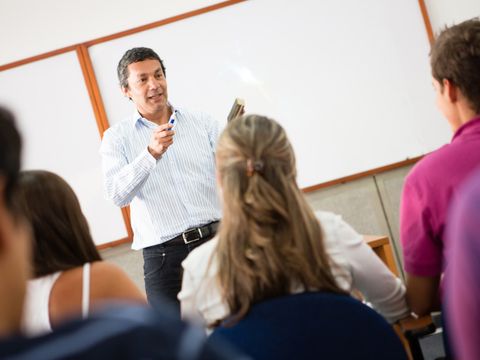 Lehrer steht vor den Schülern und erklärt