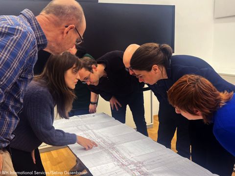 Personen schauen auf einen Plan