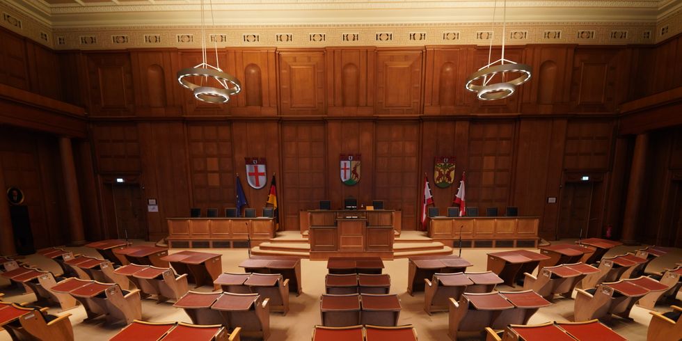Großer Saal mit alten Stühlen, die richtung Podest gerichtet sind