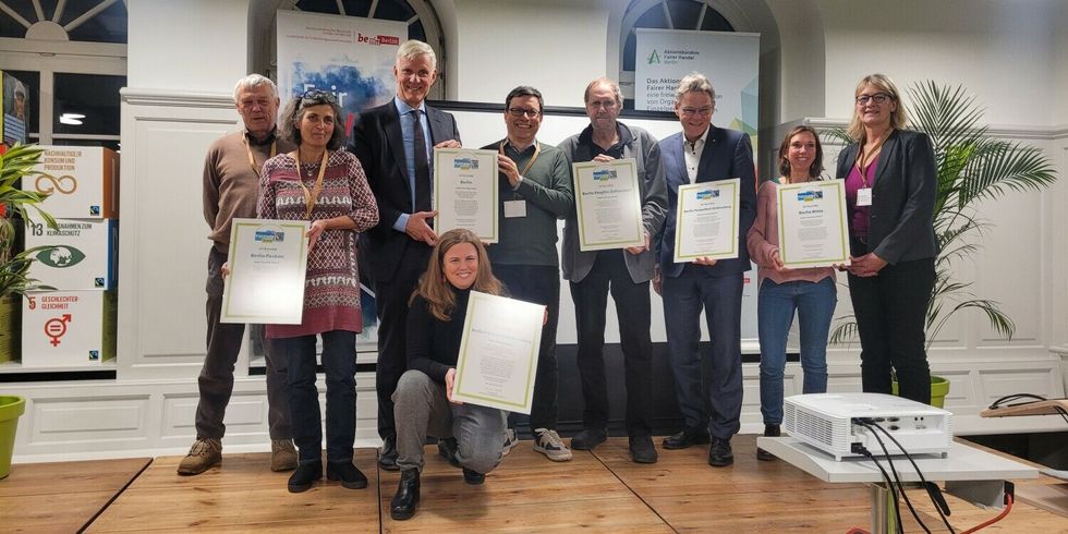 Eine Gruppe Menschen mit Auszeichnungen lächelt in die Kamera.