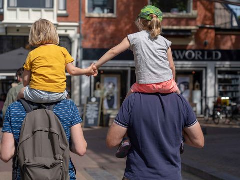 Zwei Kinder auf den Schultern ihrer Väter