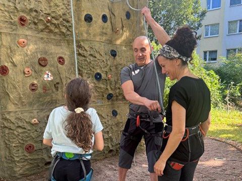 Kursleiter Danilov erklärt Mutter und Tochter das Abseilen am Kletterfelsen