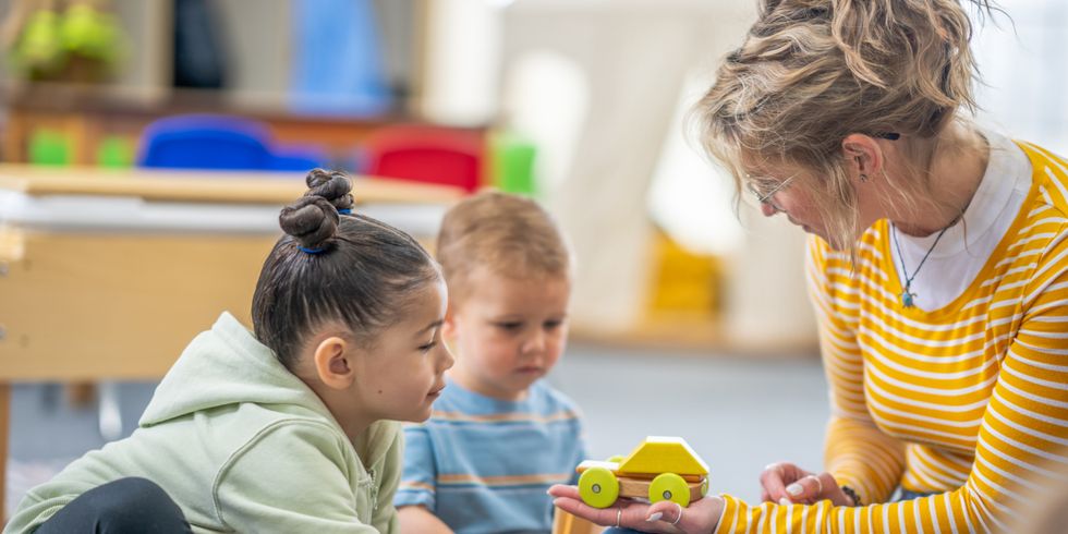 junge Frau spielt mit zwei Kleinkindern